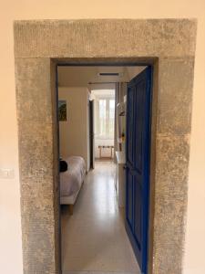 a hallway with a blue door and a bedroom at Relais il Chiostro Historic Courtyard & Panoramic Terrace near Sorrento in Massa Lubrense