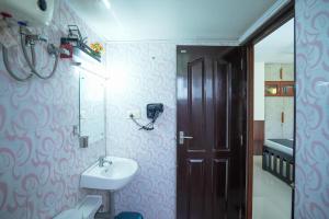 a bathroom with a sink and a toilet and a door at Sancta Maria - Accomodation For Groups -Cochin Airport in Nedumbassery +49 photos