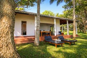 a house in the middle of a yard with trees at Bluewind Hotel in Tangalle
