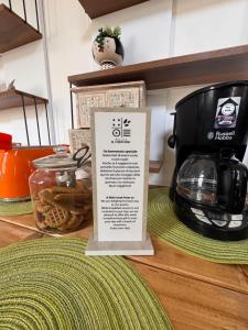 a sign sitting on top of a counter with a coffee maker at Relais il Chiostro Historic Courtyard & Panoramic Terrace near Sorrento in Massa Lubrense