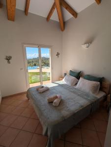 a bedroom with a large bed with two towels on it at Villa A Macchia, piscine et vue sur Bonifacio in Bonifacio +68 photos