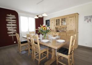 a dining room with a wooden table and chairs at LE CANT DE JUME in Gérardmer