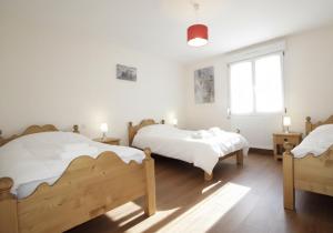 a bedroom with two beds and a window at LE CANT DE JUME in Gérardmer