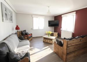 a living room with couches and a flat screen tv at LE CANT DE JUME in Gérardmer