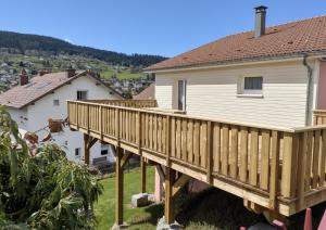 a wooden deck in front of a house at LE CANT DE JUME in Gérardmer