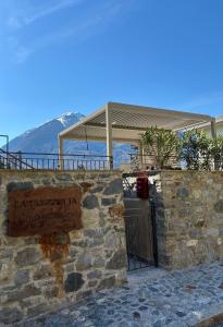 a stone wall with a sign in front of a building at La Piazzetta in Sondrio