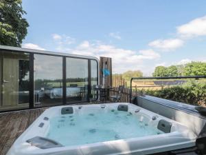 a hot tub on the deck of a house at Countryside Pod Retreat in Durston +4 photos