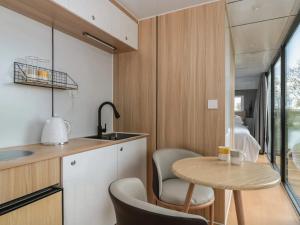a small kitchen with a small table and chairs at Countryside Pod Retreat in Durston