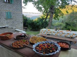 a table with several plates of food on a table with at Agricampeggio Boschetto Gioioso in Barbiano