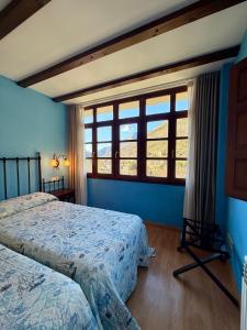 a bedroom with two beds and a large window at Casas Rurales Las Corradas in Éndriga