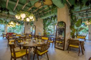 a restaurant with wooden tables and chairs and plants at Anjeliq Downtown Boutique Hotel in Alanya