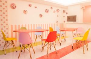 a room with tables and colorful chairs at Picnic Hostel Osaka in Osaka