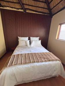 a bedroom with a large bed with white sheets and pillows at Countryview Chalet in Benoni +14 photos