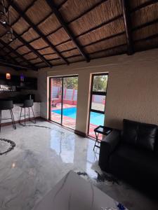 a living room with a couch and a swimming pool at Countryview Chalet in Benoni