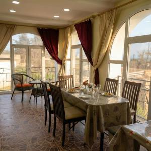 a dining room with tables and chairs and windows at Sea View villa in Baku
