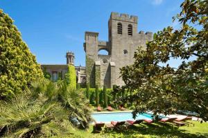 a castle with a swimming pool in front of a building at Hotel de la Cité Carcassonne - MGallery Collection in Carcassonne