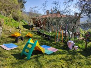 a playground with many different types of play equipment in the grass at Agricampeggio Boschetto Gioioso in Barbiano