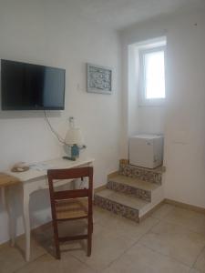 a room with a desk with a television and a chair at CASA COTA in Mattinata