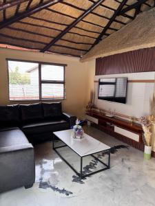 a living room with a couch and a table at Countryview Chalet in Benoni