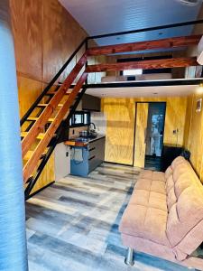 a living room with a couch and a staircase at Barra Loft in Piriápolis