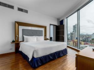 a bedroom with a large bed and a large window at Novotel Panama City in Panama City +70 photos