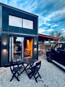 a black tiny house with a picnic table and a car at Barra Loft in Piriápolis