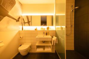 a bathroom with a sink and a toilet at Motorworld Inn Hotel Böblingen in Böblingen