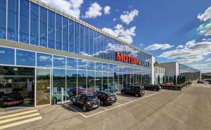 a parking lot with cars parked in front of a building at Motorworld Inn Hotel Böblingen in Böblingen