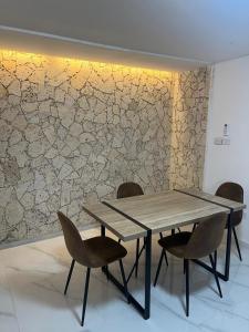 a table and chairs in a room with a wall at 10 Caribe, tranquilidad y Casa Familiar in Rodadero