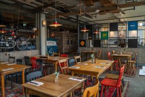 a restaurant with wooden tables and chairs in a room at Motorworld Inn Hotel Böblingen in Böblingen