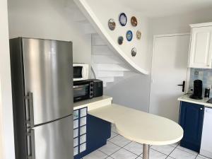 a kitchen with a stainless steel refrigerator and stairs at maison Basque Maïana in Anglet