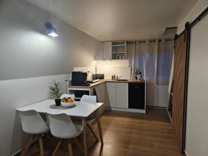 a small kitchen with a white table and chairs at Finnhaus 1 Strandbad Adria in Kleutsch