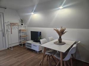 a dining room with a table and a television at Finnhaus 1 Strandbad Adria in Kleutsch