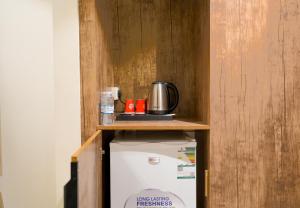 a cabinet with a coffee pot on top of a refrigerator at فندق الخلفاء الماسى الفندقيه in Mecca