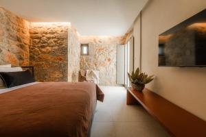 a bedroom with a bed and a stone wall at Nest Limeni in Limeni