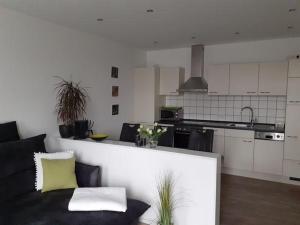 a living room with a couch and a kitchen at Op-England-I-mit-Terrasse-grossem-Garten in Nordstrand