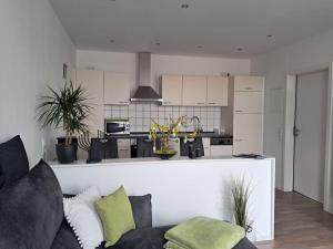 a living room with a couch and a kitchen at Op-England-I-mit-Terrasse-grossem-Garten in Nordstrand