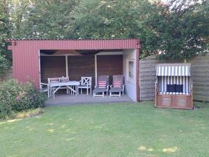 a small shed with a table and chairs on it at Op-England-I-mit-Terrasse-grossem-Garten in Nordstrand
