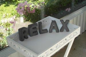 a white bench with the word relax written on it at Op-England-I-mit-Terrasse-grossem-Garten in Nordstrand +15 photos