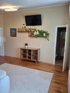 a living room with a tv on a wall at Po Beržu in Molėtai
