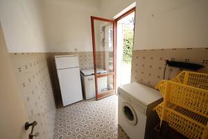 a laundry room with a washer and a door to a kitchen at Villa Pentalocale cod 168- Taunus Vacanze in Numana
