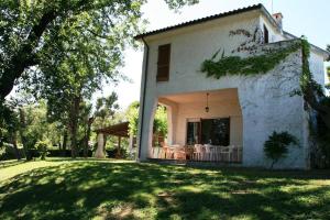 a white house with a large yard with a porch at Villa Pentalocale cod 168- Taunus Vacanze in Numana