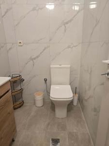 a white bathroom with a toilet and a sink at Quite room double bed in Florina