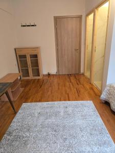 an empty living room with wooden floors and a door at Quite room double bed in Florina