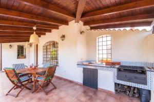 a patio with a table and chairs and a fireplace at Villa Le Sterlizie in Castellammare del Golfo
