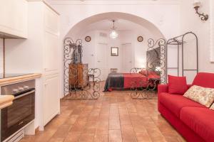 a living room with a red couch and a bed at Boschetto 58 in Rome +14 photos