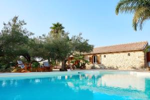 a large swimming pool in front of a house at Villa Le Sterlizie in Castellammare del Golfo
