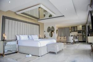 a bedroom with a large white bed and a living room at Nandoni Waterfront Resort in Thohoyandou