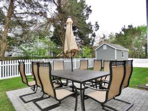 a patio table and chairs with an umbrella at The Sunrise On Sunset in West Cape May