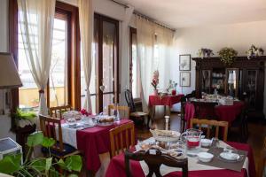 a dining room with tables with red tablecloths at B&B Dei Cavalieri in Pisa